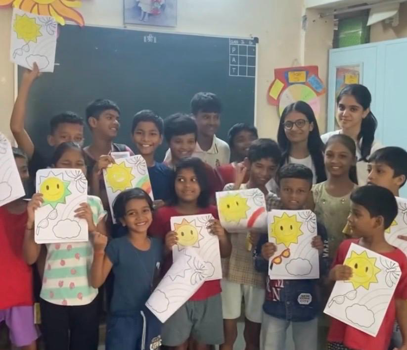 Students holding creative activity artwork
