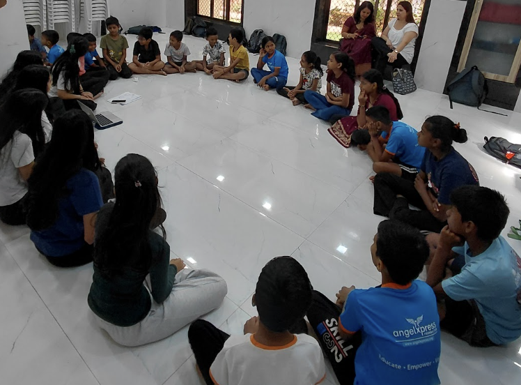 Children seated in a circle for a group discussion at Angel Xpress Foundation